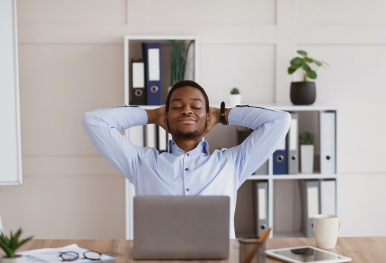 A relaxed professional sitting back at his desk with a smile, illustrating the time-saving benefits of Agentic AI workflow